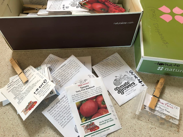 Box of seed packages and some on counter with clips