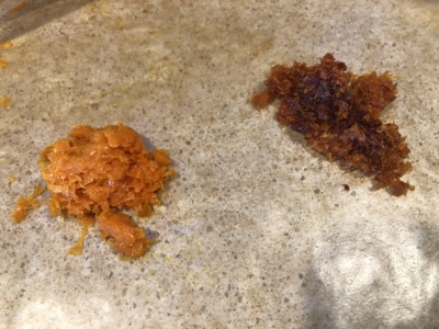 two piles of orange zest, orange on  left, blood orange on right