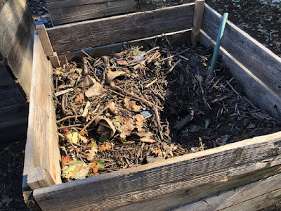 Wooden compost bin with leaves