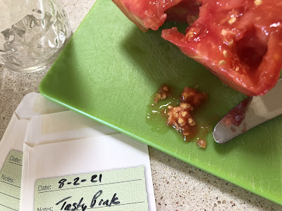 Tomato slice with seeds on a green cutting board