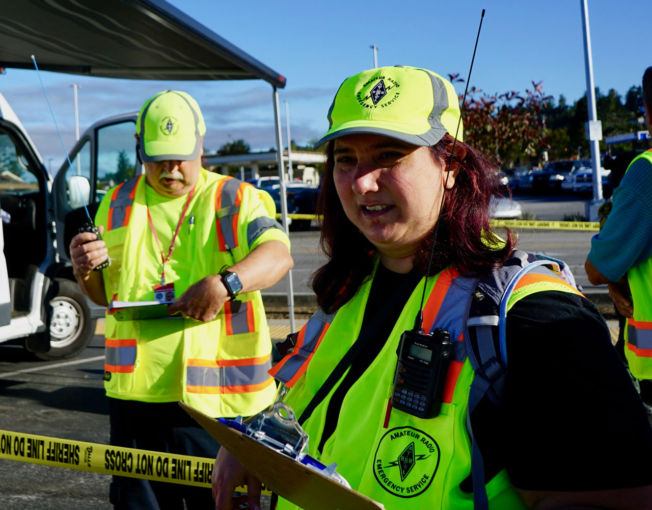 Two volunteers wearing ARES vests and hats